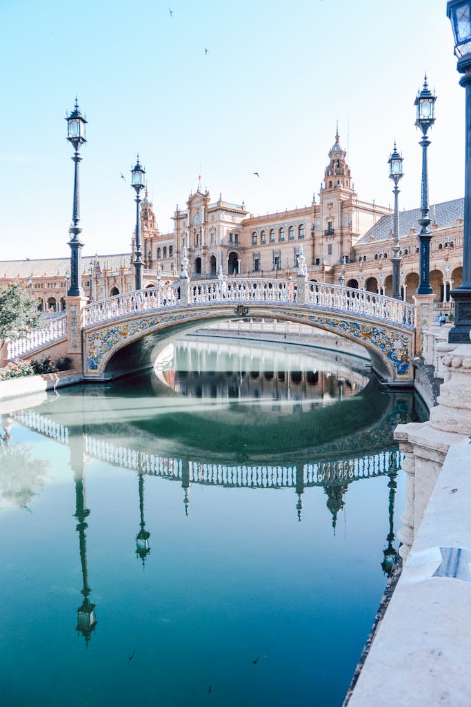 Bridge, Lampposts, Body of Water, and Buildings during Day